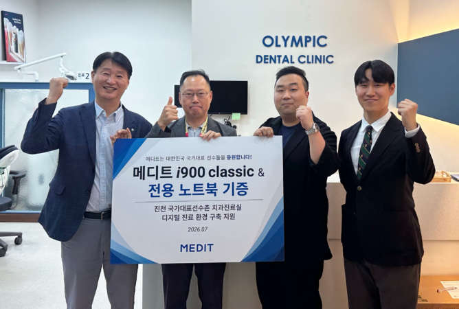 기증식 현장 사진_수정2 1 - Medit Intraoral Scanner and Dental Software Quatro homens vestidos com trajes profissionais posam no saguão de uma clínica odontológica, segurando uma grande faixa com texto em coreano e a palavra “medit” visível. Atrás deles, na parede, está escrito “Olympic Dental Clinic” em letras azuis.